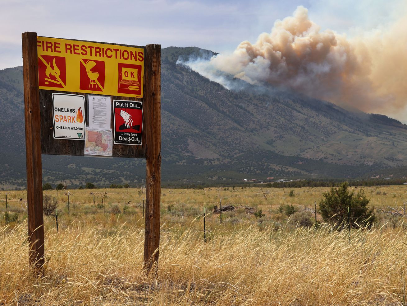 A fire restriction sign sits along a road in Rush Valley as a wildfire burns on Victory Mountain in Morgan Canyon in
Tooele County on Tuesday, June 22, 2021. The fire started after a plane crash. As wildfires rage across multiple states in the West, the Bipartisan Wildfire Caucus co-chaired by Rep. John Curtis, R-Utah, detailed the urgency to improve forest management and put
additional resources on the ground.