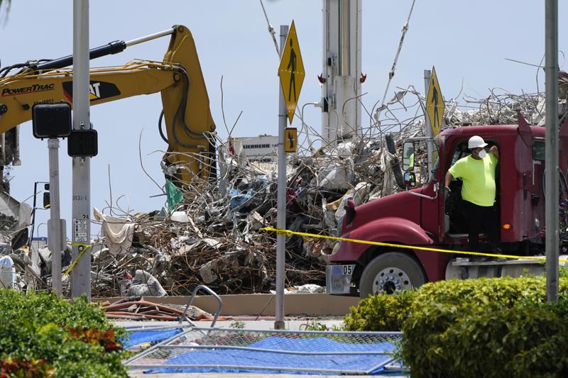 A worker waits to load his truck with debris from the rubble of the Champlain Towers South building, as removal and recovery work continues at the site of the partially collapsed condo building, Wednesday, July 14, 2021, in Surfside, Fla. 
