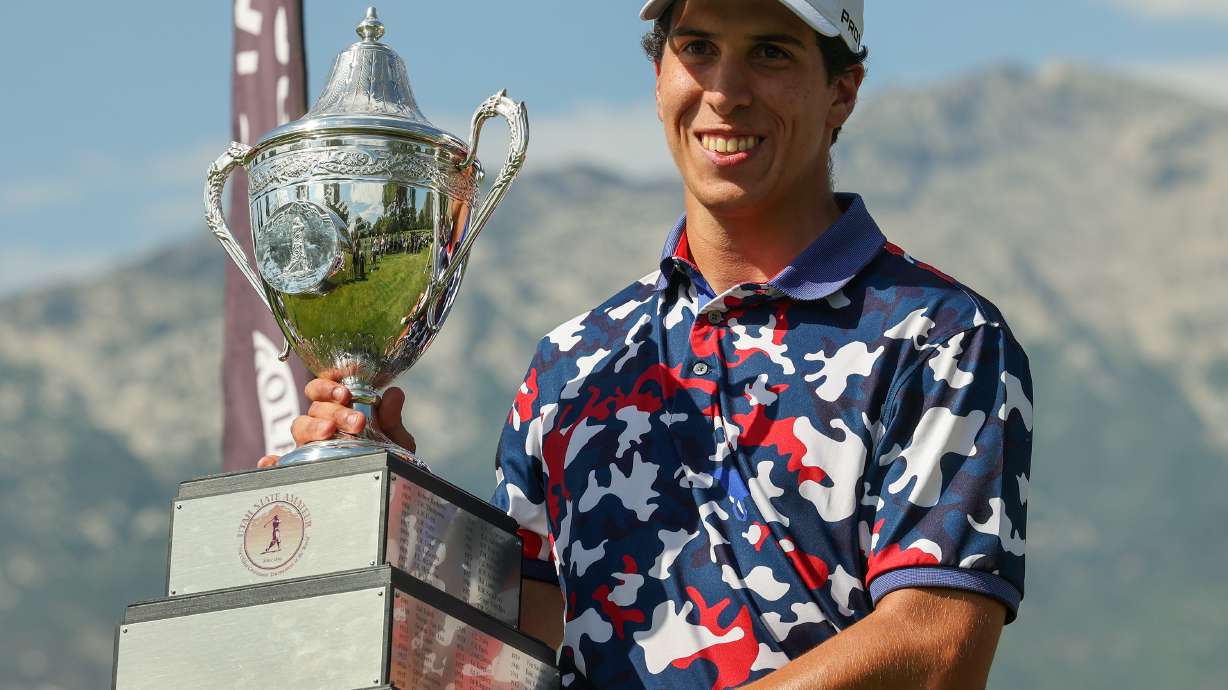 University of Utah redshirt freshman Martin Leon holds up the champions trophy after defeating teammate Blake Tomlinson in the final round of play in the Utah State Amateur at Alpine Country Club on Saturday, July 17, 2021. Leon won the championship in 39 holes.