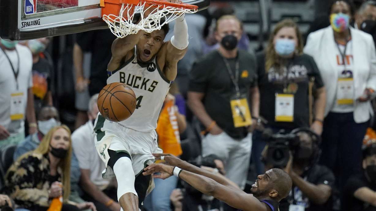 Milwaukee Bucks forward Giannis Antetokounmpo, top, dunks over Phoenix Suns guard Chris Paul during the second half of Game 5 of basketball's NBA Finals, Saturday, July 17, 2021, in Phoenix.
