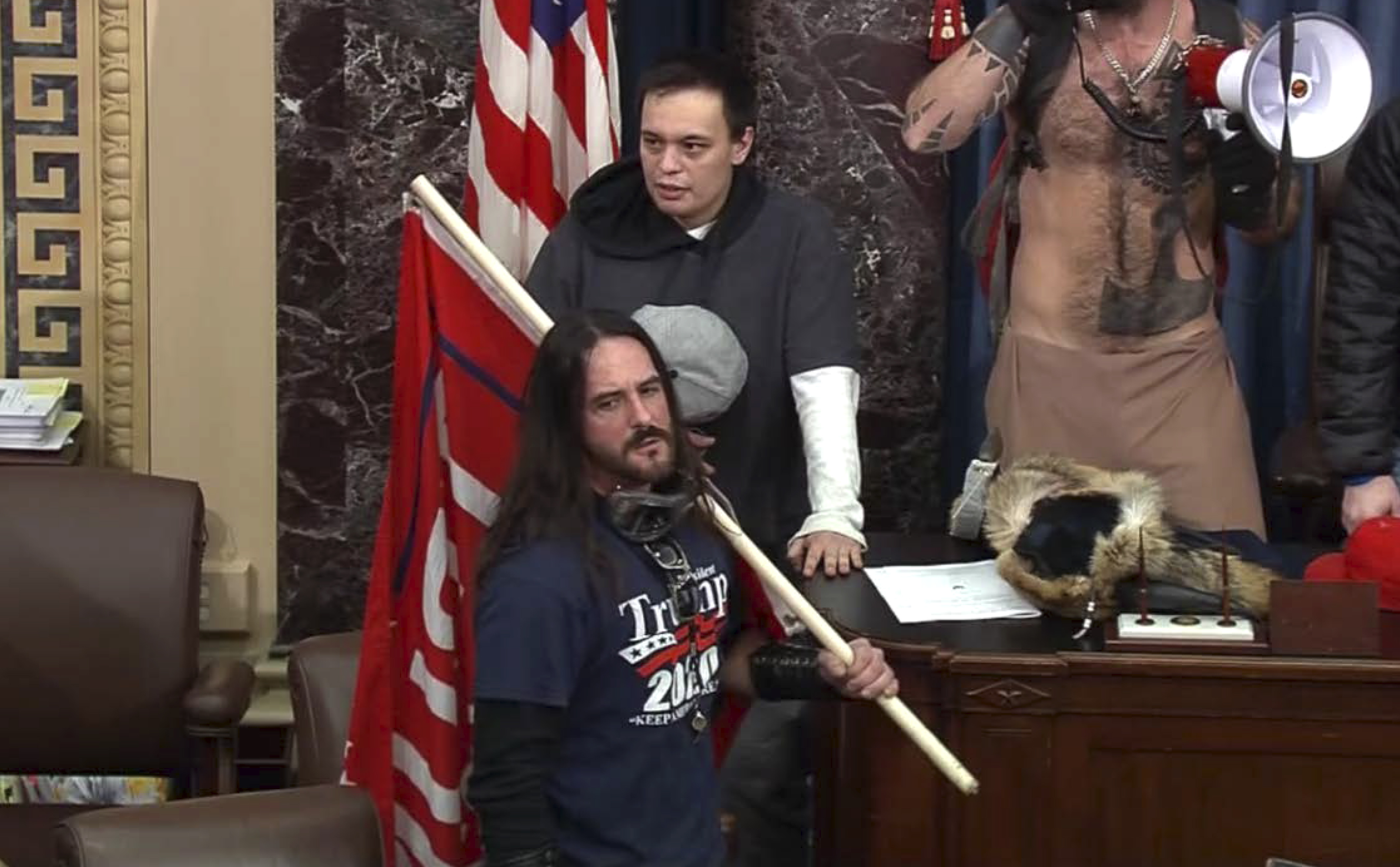 In this file image from U.S. Capitol Police video, Paul Allard Hodgkins, 38, of Tampa, Fla., front, stands in the well on the floor of the U.S. Senate on Jan. 6, 2021, at the Capitol in Washington. Hodgkins was sentenced Monday to eight months behind bars for his role in the Capitol insurrection.