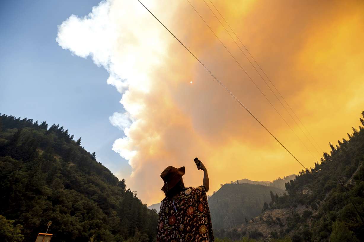 Jessica Bell takes a video as the Dixie Fire burns along Highway 70 in Plumas National Forest, Calif., on Friday, July 16, 2021.
