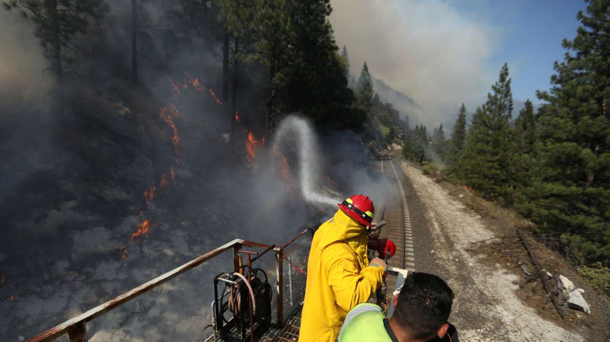 Firefighters assigned to the Union Pacific Fire Train protect the tracks and hinder the Dixie Fire from crossing the North Fork of the Feather River in Plumas National Forest, California, U.S., July 17, 2021.