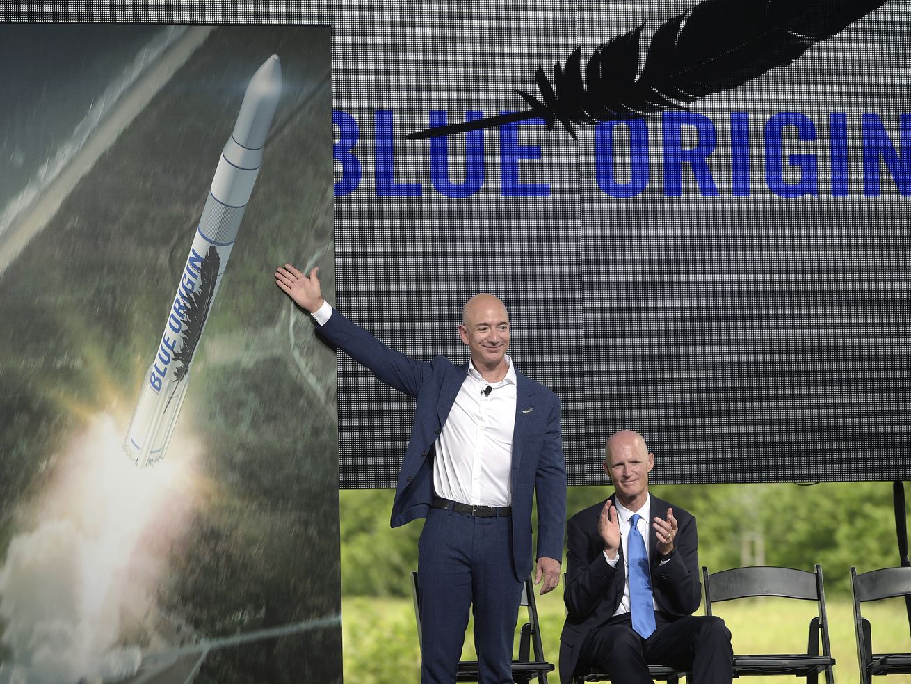 Amazon CEO Jeff Bezos, left, unveils the new Blue Origin rocket, as Florida Gov. Rick Scott applauds, during a news
conference at the Cape Canaveral Air Force Station in Cape Canaveral, Fla., on Sept. 15, 2015.