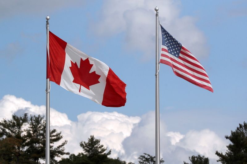 A U.S. and a Canadian flag flutter at the Canada-United States border crossing at the Thousand Islands Bridge in Lansdowne, Ontario, Canada on Sept. 28, 2020.