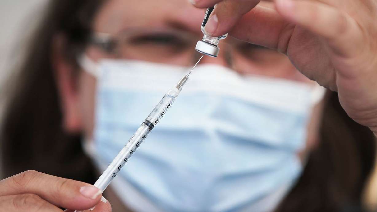 Clarece Glanville prepares a COVID-19 vaccination at pop-up clinic sponsored by the Davis County Health Department in the parking lot of Kent’s Market in Clearfield on Wednesday, June 23, 2021. Sen. Mitt Romney, R-Utah, said Tuesday he and others are
ready for a COVID-19 booster shot and expressed frustration during a Senate hearing that a third vaccination against the deadly virus is already available in some countries including Israel but not the United States.