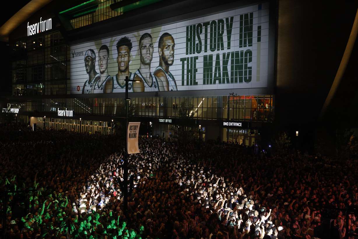 Fans watch television coverage of the Milwaukee Bucks and Phoenix Suns playing in Game 6 of the NBA basketball finals Tuesday, July 20, 2021, in Milwaukee.