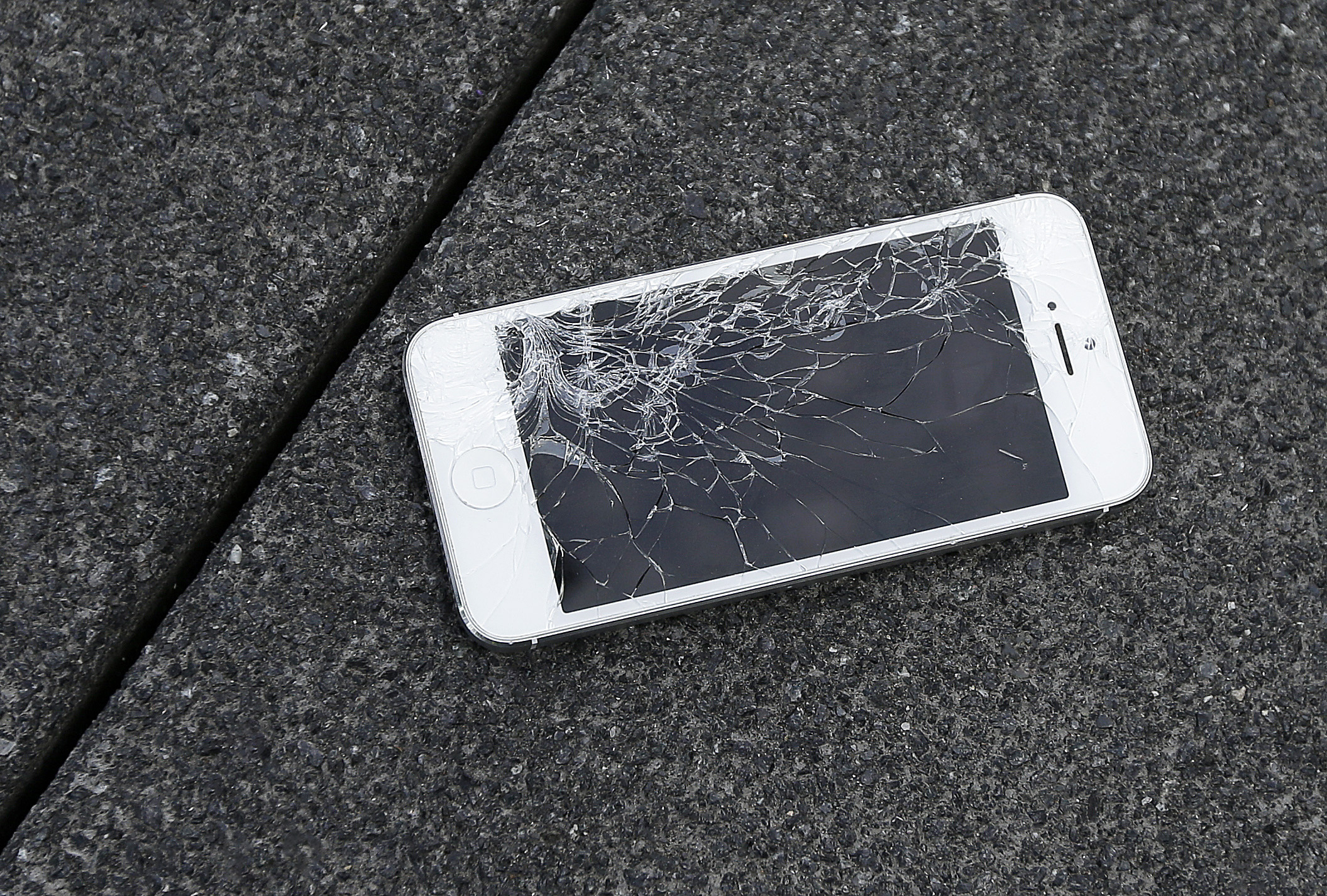 This Aug. 26, 2015 photo shows an Apple iPhone with a cracked screen after a drop test from the DropBot, a robot used to measure the sustainability of a phone to dropping, at the offices of SquareTrade in San Francisco. Responding to a new competition directive from the Biden White House, Wednesday, July 21, 2021, the Federal Trade Commission is moving toward writing new rules aimed at helping small repair businesses and saving consumers money on repair costs.
