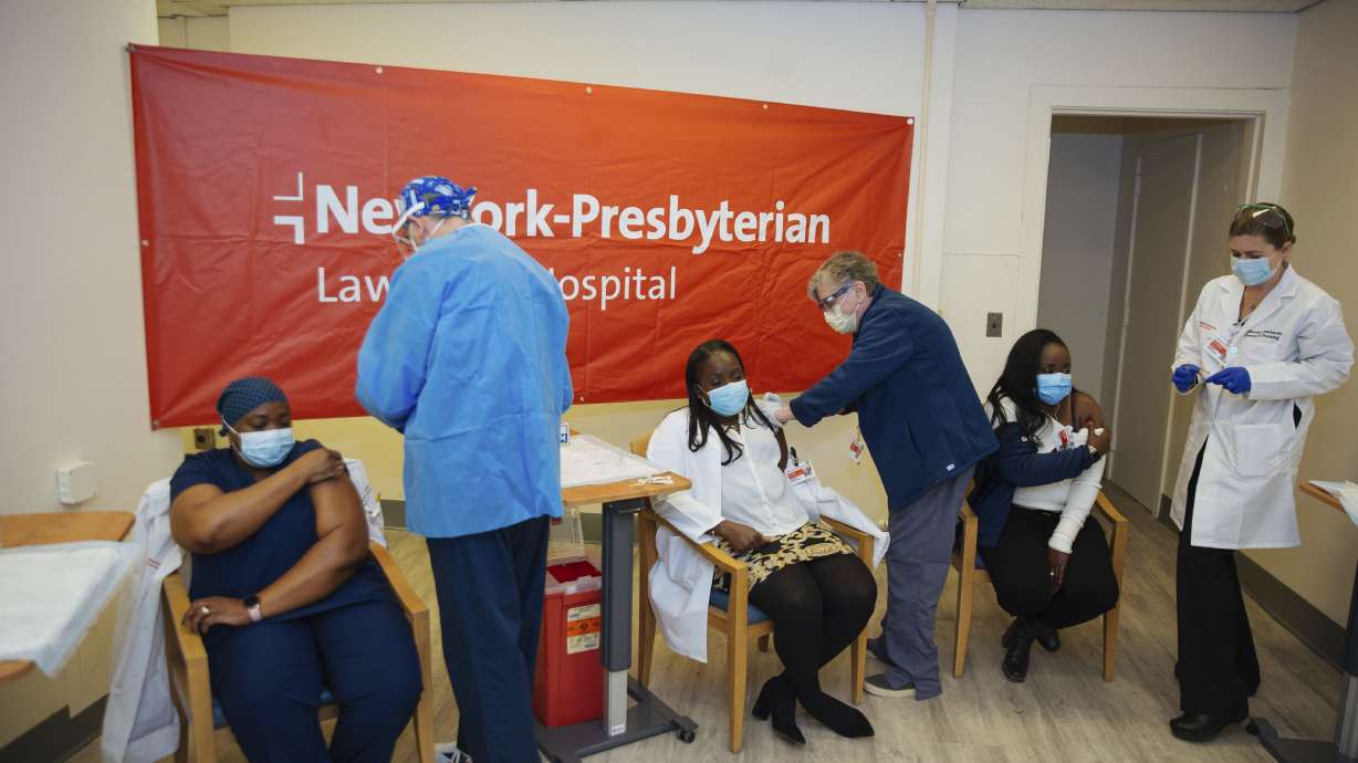 Doctors inject sisters Claudia Scott-Mighty, left, Althea Scott-Bonaparte, who are patient care directors, and Christine Scott, an ICU nurse, with their second shot of the Pfizer vaccine at New York-Presbyterian Lawrence Hospital, in Bronxville, N.Y. on Jan. 8, 2021.