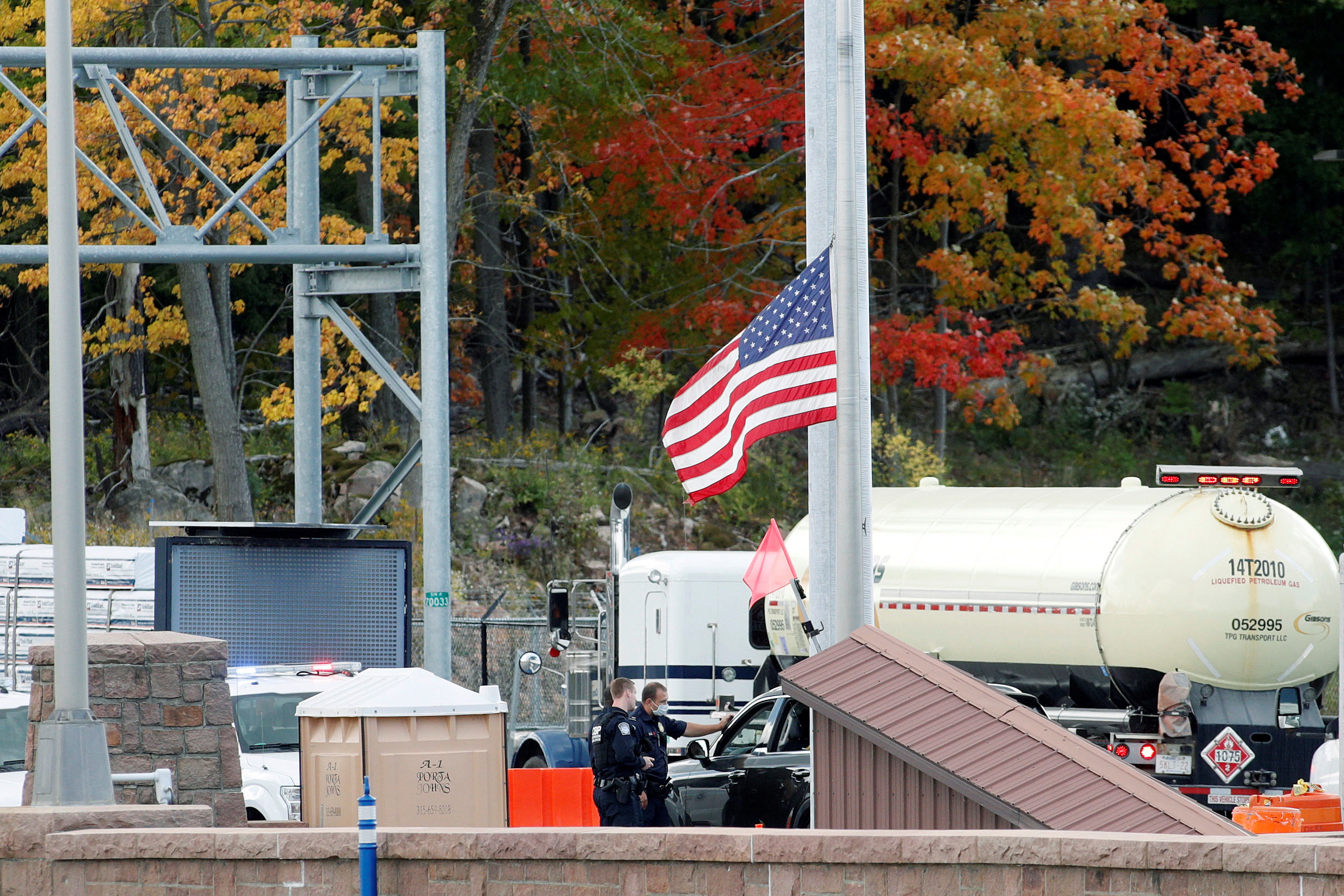 U.S. customs officers speak with a person at the Canada-United States border crossing at the Thousand Islands Bridge, which remains closed to non-essential traffic to combat the spread of the coronavirus disease in Lansdowne, Ontario, Canada, Sept. 28, 2020. Travel restrictions have been extended to Aug. 21, 2021.