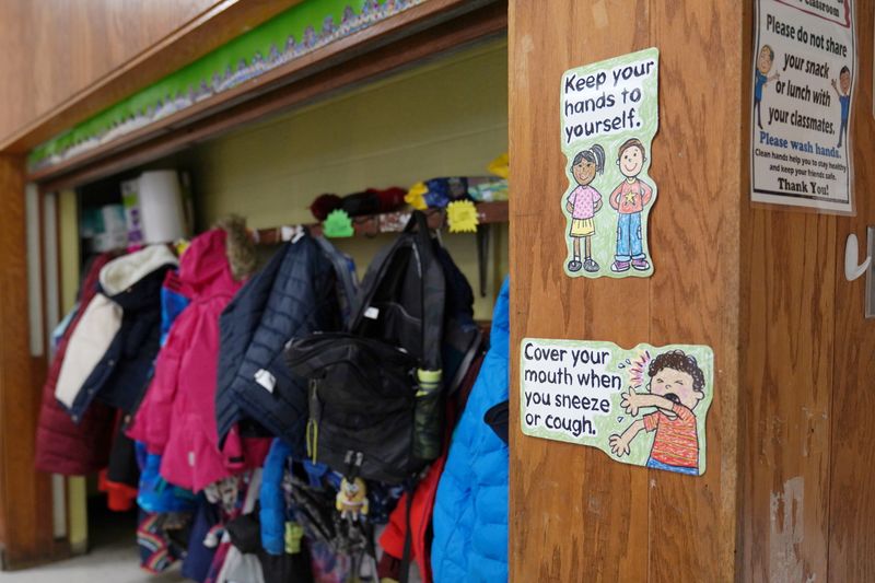 Signs hang to remind children of precautions to prevent the spread of the coronavirus disease (COVID-19) in the classroom at South Boston Catholic Academy in Boston, Massachusetts, U.S., January 28, 2021.