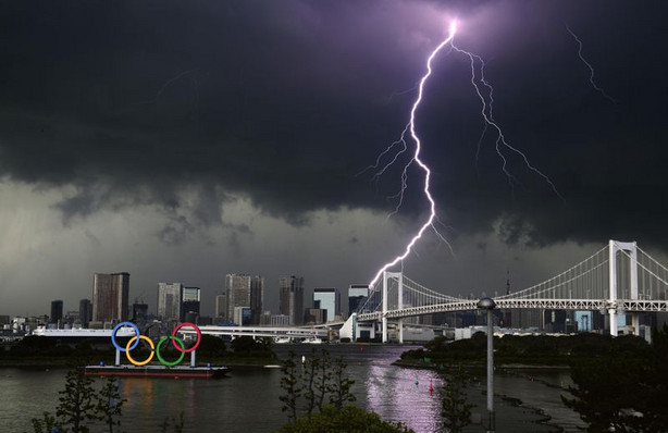 Lightning illuminates the sky over the Olympic rings
and the Rainbow Bridge in Tokyo on Sunday, July 11,
2021.