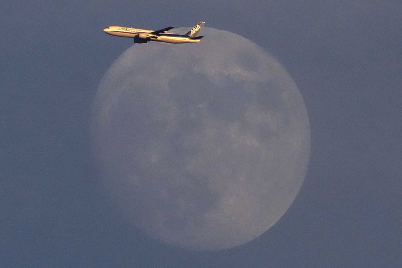 An All Nippon Airways passenger jet climbs past the
rising moon after taking off from Haneda Airport on the eve of the
pandemic-delayed 2020 Summer Olympics on Thursday, July 22, 2021,
in Tokyo.