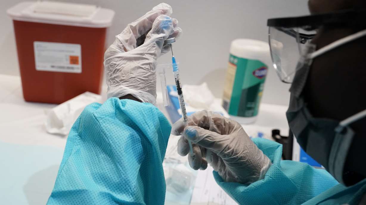 In this July 22, 2021 photo, a health care worker fills a syringe with the Pfizer COVID-19 vaccine at the American Museum of Natural History in New York. Most Americans who haven’t been vaccinated against COVID-19 say they are unlikely to get the shots and doubt they would work against the aggressive delta variant despite evidence they do, according to a new poll.
