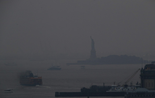 The Staten Island Ferry departs from the Manhattan terminal through a haze of smoke with the Statue of Liberty barely visible, Tuesday, July 20, 2021, in New York. Wildfires in the American West, including one burning in Oregon that's currently the largest in the U.S., are creating hazy skies as far away as New York as the massive infernos spew smoke and ash into the air in columns up to six miles high.