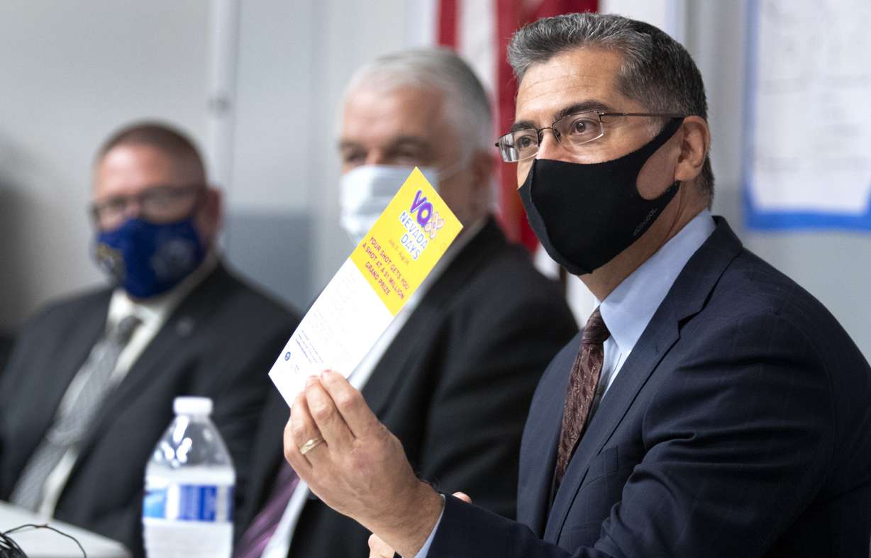 In this July 22, 2021 file photo, U.S. Department of Health and Human Services Secretary Xavier Becerra holds up a flier promoting the Vax Nevada Days lottery after briefing from officials at the Clark County Fire Department Training Facility in Las Vegas.
