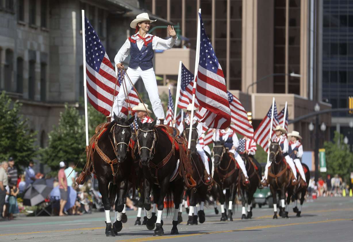 A woman straddles two horses in the Days of '47 Parade in Salt Lake City on Friday, July 23, 2021.