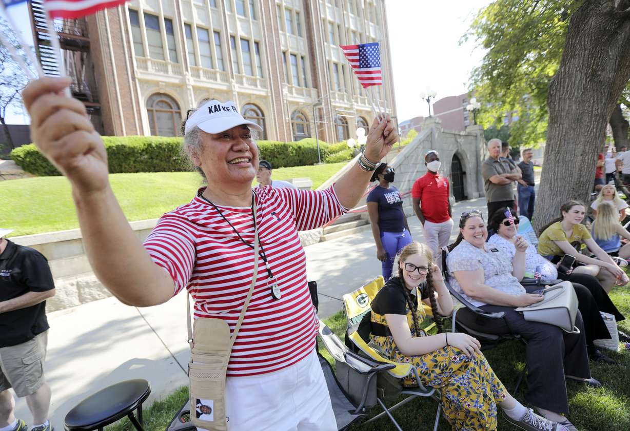 Mele Takuvaka waves flags and cheers as she watches the Days of '47 Parade in Salt Lake City on Friday, July 23, 2021.