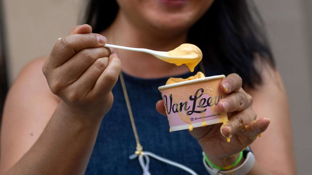 A woman enjoys new Kraft Macaroni & Cheese ice cream near Union Square in New York City on July 14, 2020.