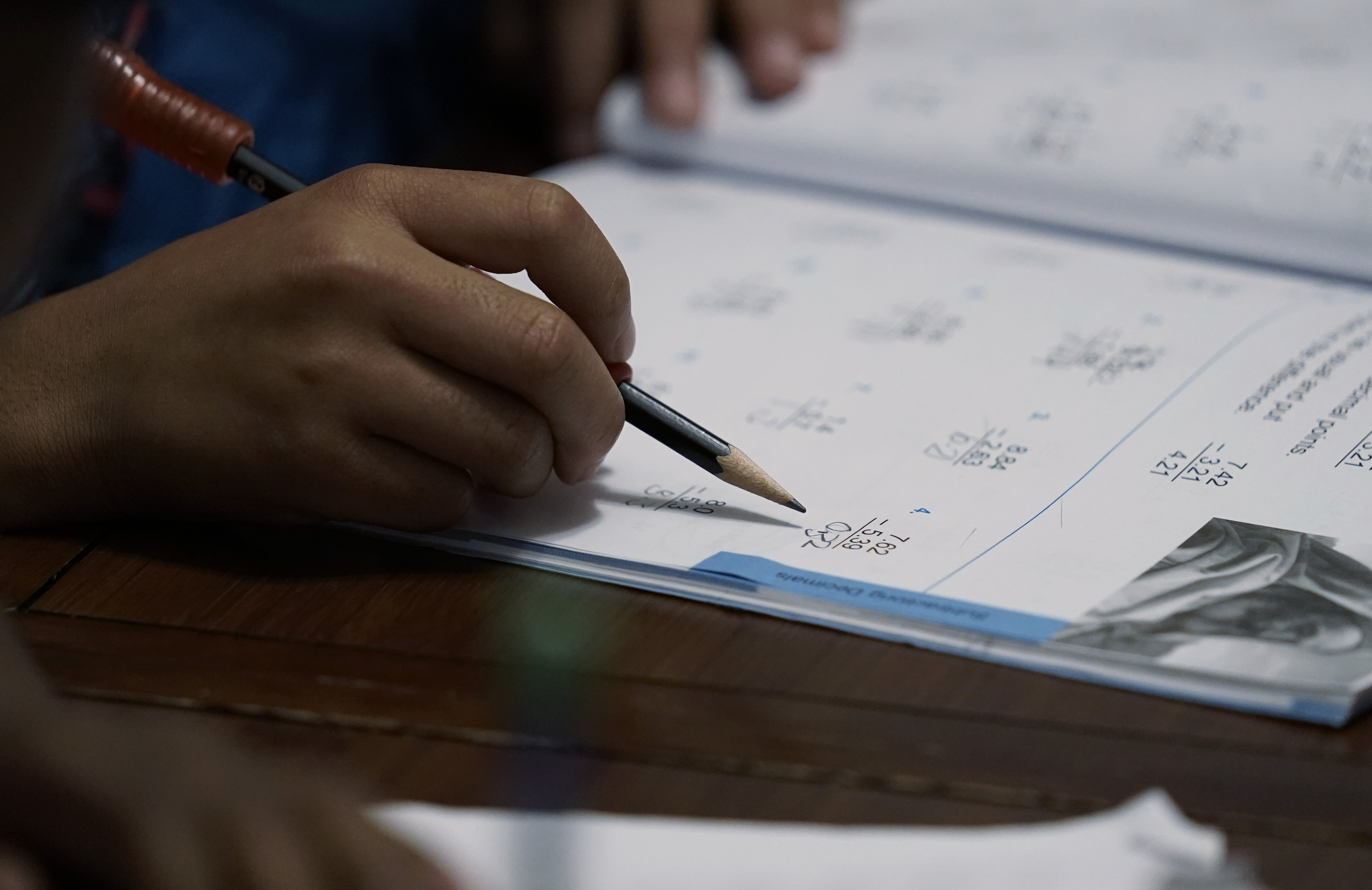 Felicity Brown, 9, uses a workbook to practice math with her parents and siblings at home in Austin, Texas, on Tuesday, July 13, 2021. After homeschooling during the pandemic, the Brown family has switched to homeschooling their kids permanently.