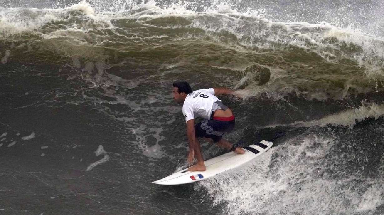France's Jeremy Flores surfs a wave during the third round of the men's surfing competition at the 2020 Summer Olympics, Monday, at Tsurigasaki beach in Ichinomiya, Japan. A typhoon arriving Tuesday morning is forecast to disrupt at least some parts of the Games.
