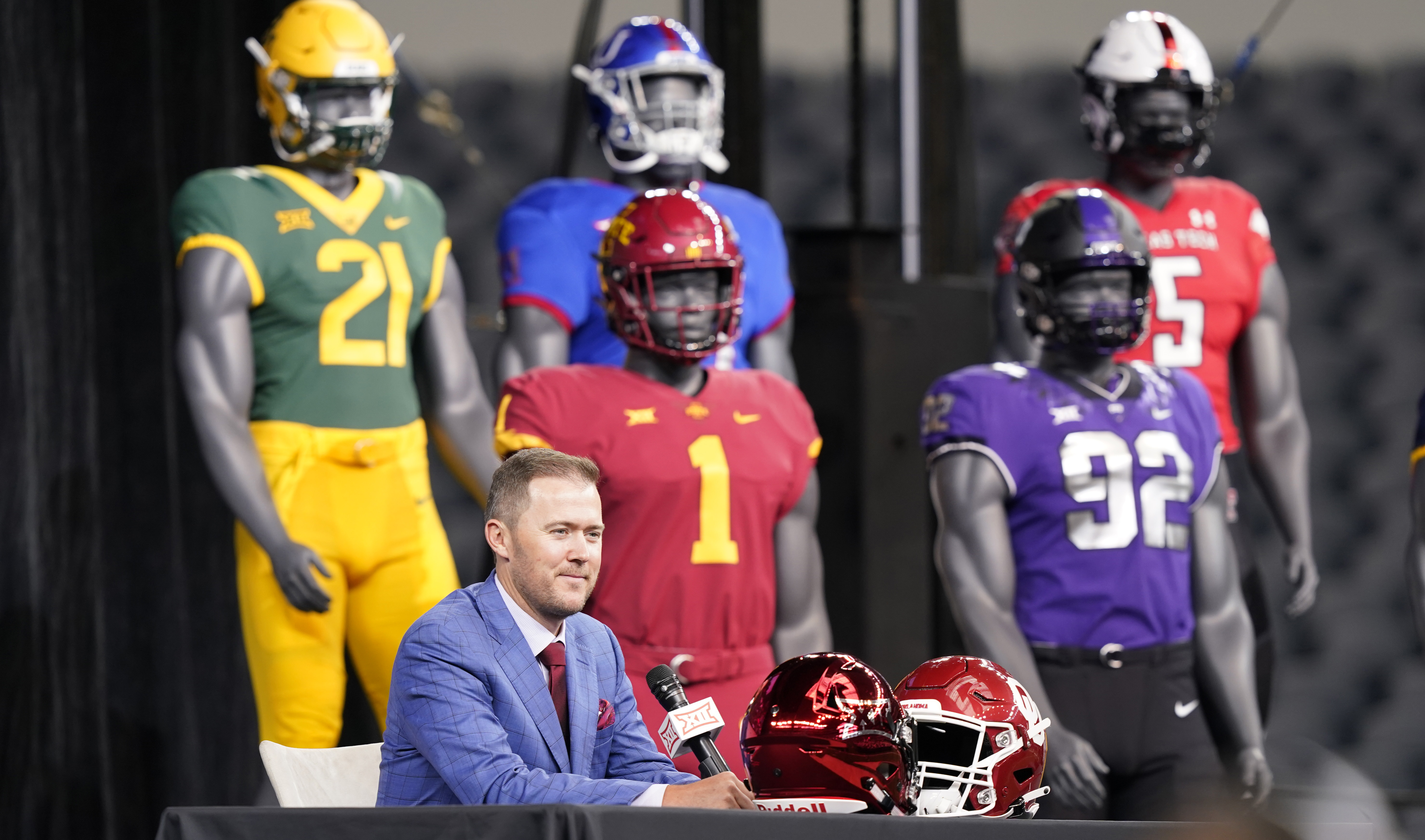Oklahoma head football coach Lincoln Riley speaks from the stage with mannequins in the back ground during NCAA college football Big 12 media days Wednesday, July 14, 2021, in Arlington, Texas. 