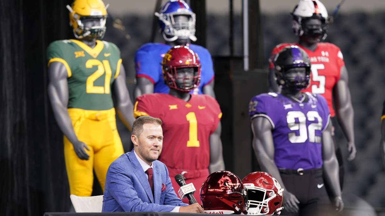 Oklahoma head football coach Lincoln Riley speaks from the stage with mannequins in the back ground during NCAA college football Big 12 media days Wednesday, July 14, 2021, in Arlington, Texas.