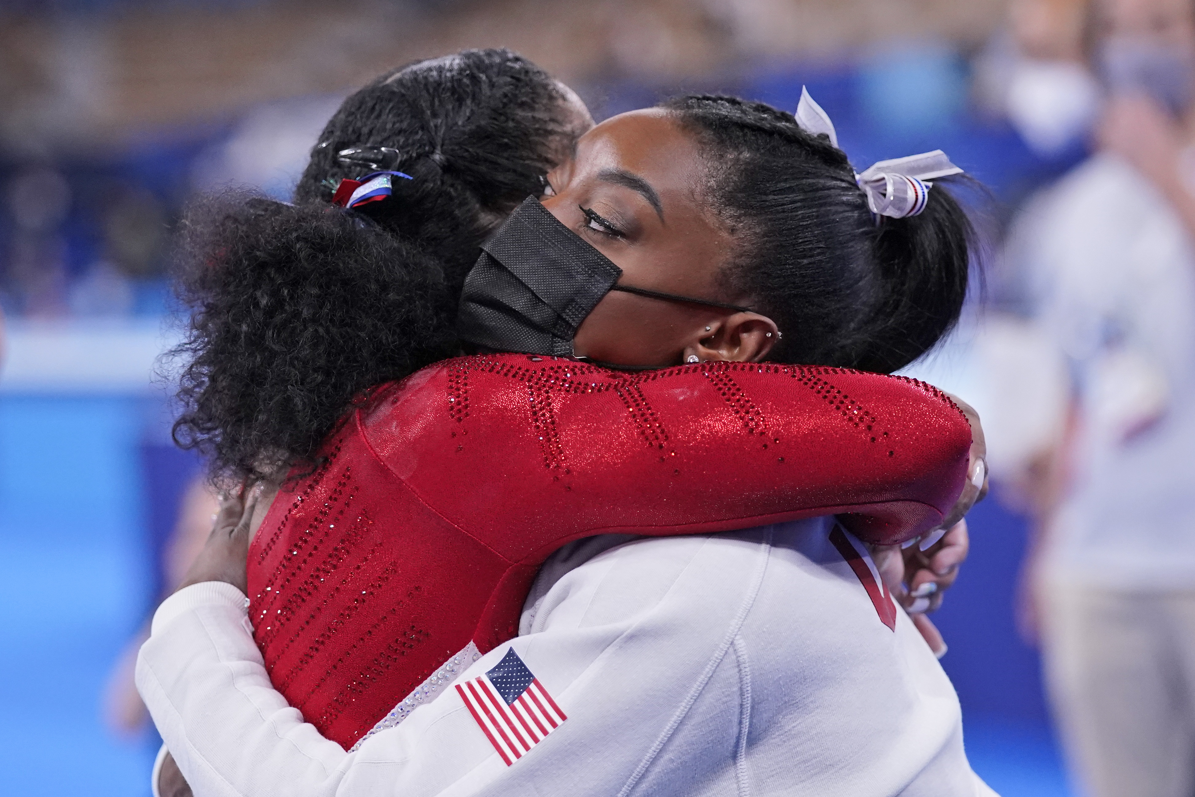 Simone Biles, of the United States, embraces teammate Jordan Chiles after she exited the team final with apparent injury, at the 2020 Summer Olympics, Tuesday, July 27, 2021, in Tokyo. The 24-year-old reigning Olympic gymnastics champion Biles huddled with a trainer after landing her vault. She then exited the competition floor with the team doctor.