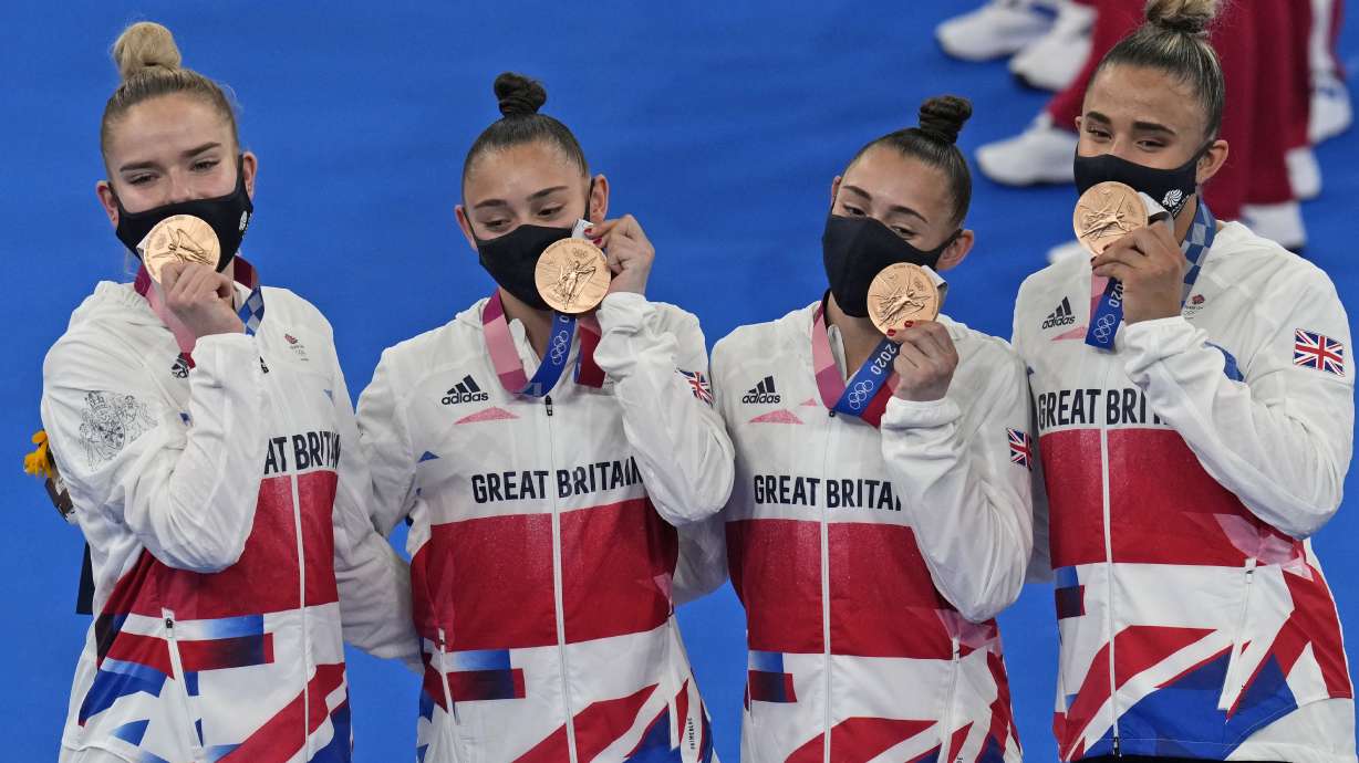 Team Britain, comprising of Jennifer Gadirova, Jessica Gadirova, Alice Kinsella and Amelie Morgan, celebrate after winning bronze in the artistic women's team pose after winning the bronze medal at the 2020 Summer Olympics, Tuesday, July 27, 2021, in Tokyo.