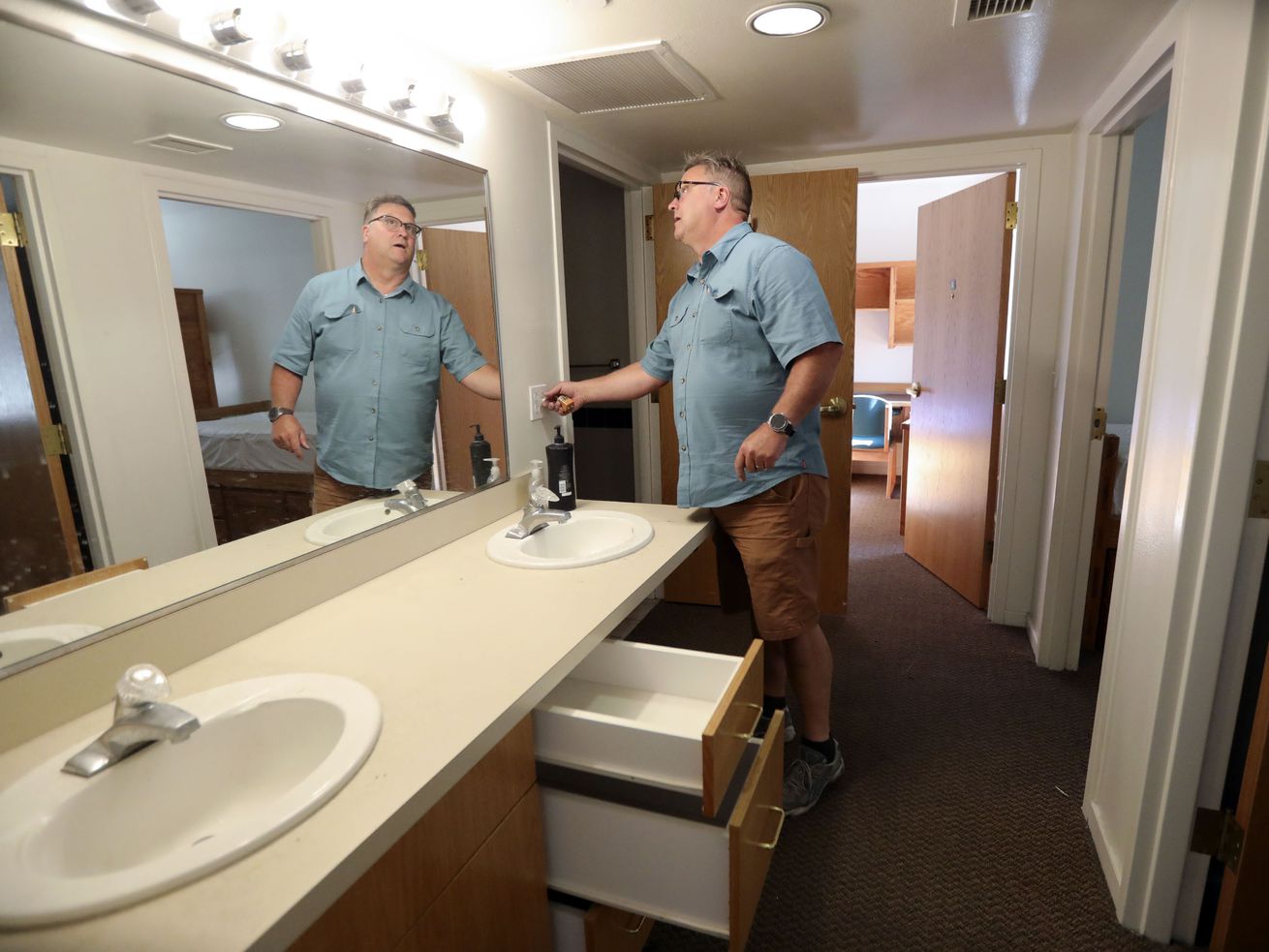 Mark Vittum, Westminster College maintenance
technician, checks lightbulbs and power outlets in an Olwell Hall
dorm at Westminster College in Salt Lake City on Tuesday, June 22,
2021.