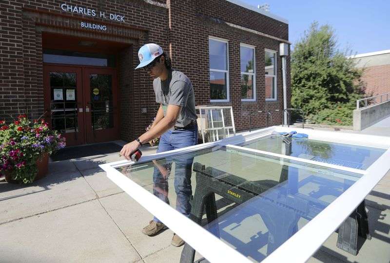 Payton Romero, with City Glass, measures a new window
for installation in the Charles H. Dick building at Westminster
College in Salt Lake City on Tuesday, June 22, 2021.