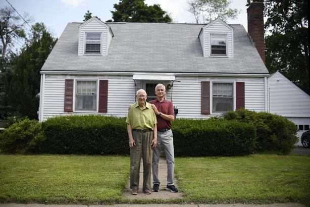 In this Saturday, July 17, 2021, photo, Fred Ware, left, stands outside his home with his son Dave Ware in Manchester, Conn. Fred and Dave Ware recently found a whites-only covenant on his property dating back to 1942 when researching the title chain. Upon finding the covenant, Dave Ware, who grew up in the home, reached out to state lawmakers and helped get a bill passed that strips these covenants on properties.