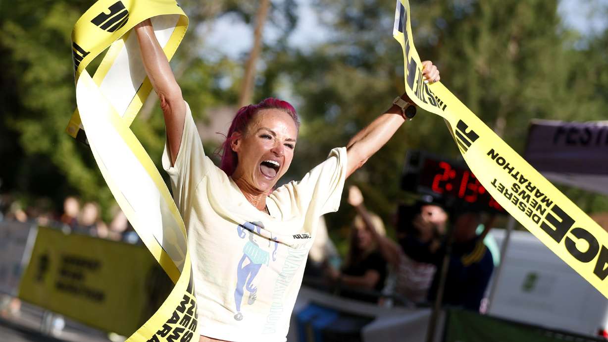 Ashley Paulson celebrates as she finishes first in the women's division of the Deseret News Marathon in Salt Lake City on Friday, July 23.