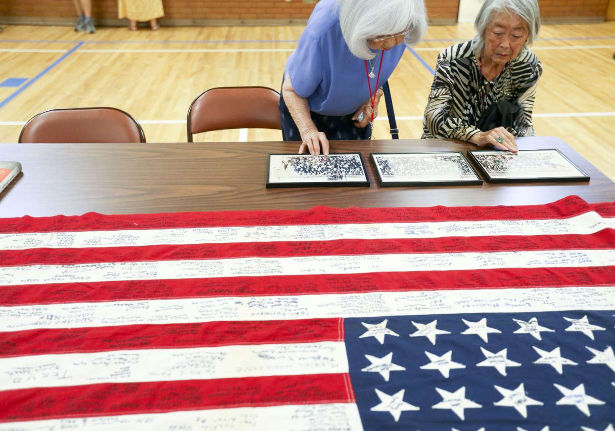 Jeanette Mitari Misaka, left, and Yoshiko Mayeda Uno look at photographs from World War II concentration camps such as Heart Mountain and Topaz at the Salt Lake Buddhist Temple on Wednesday.