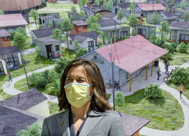 Salt Lake City Mayor Erin Mendenhall stands in front of
a conceptual drawing for The Other Side Village — a tiny home
community to serve people experiencing chronic homelessness —
during a press conference at the City-County Building on Thursday,
April 28, 2021. During the press conference, Mendenhall announced a
partnership with The Other Side Academy to create the community by
wintertime.