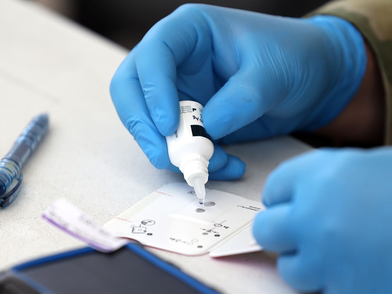 Utah National Guard Pfc. Jacob Osborne, with 19th
Special Forces at Camp Williams in Bluffdale, applies a reagent to
a BinaxNOW COVID-19 Ag Card at a COVID-19 testing site at the Utah
State Fairpark in Salt Lake City on Tuesday, July 6, 2021.