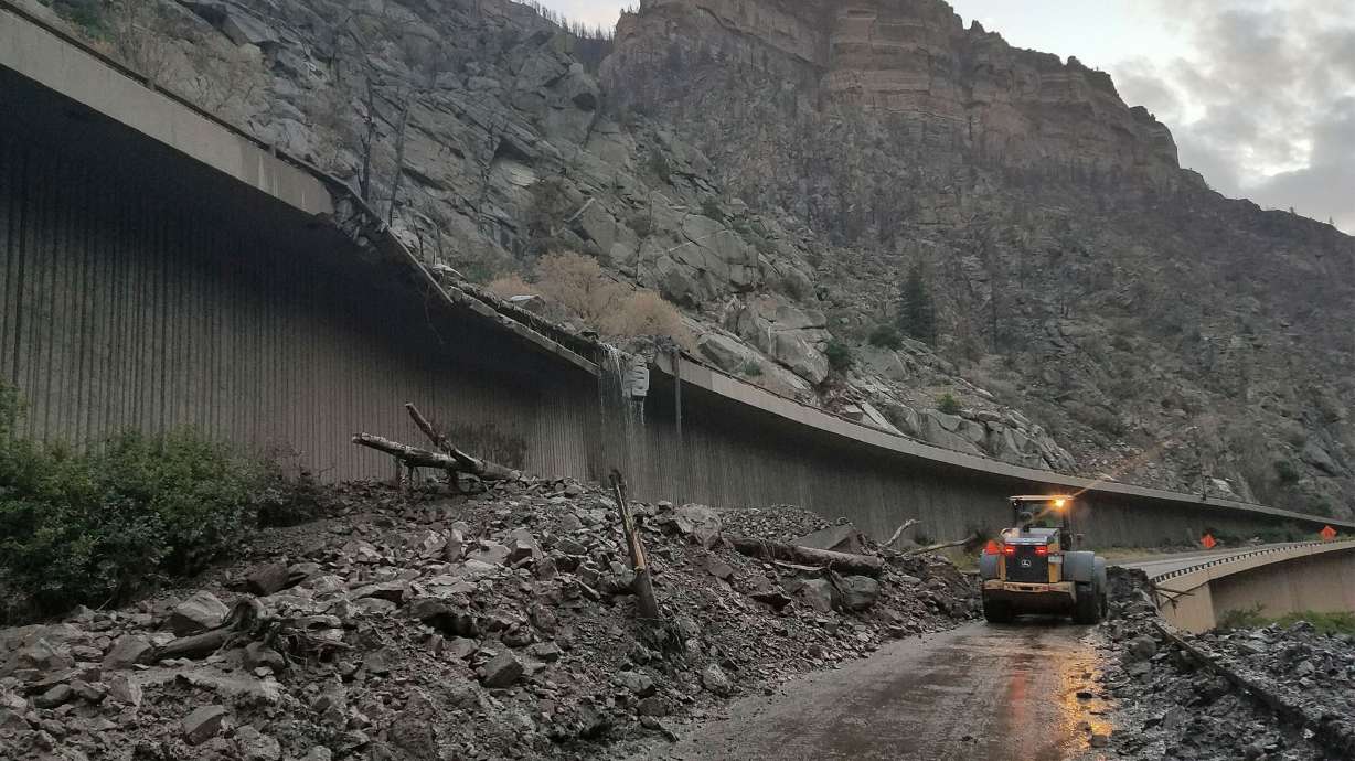 Equipment works to clear mud and debris from a mudslide on I-70 in Glenwood Canyon, Colorado. The road remains closed into the weekend.