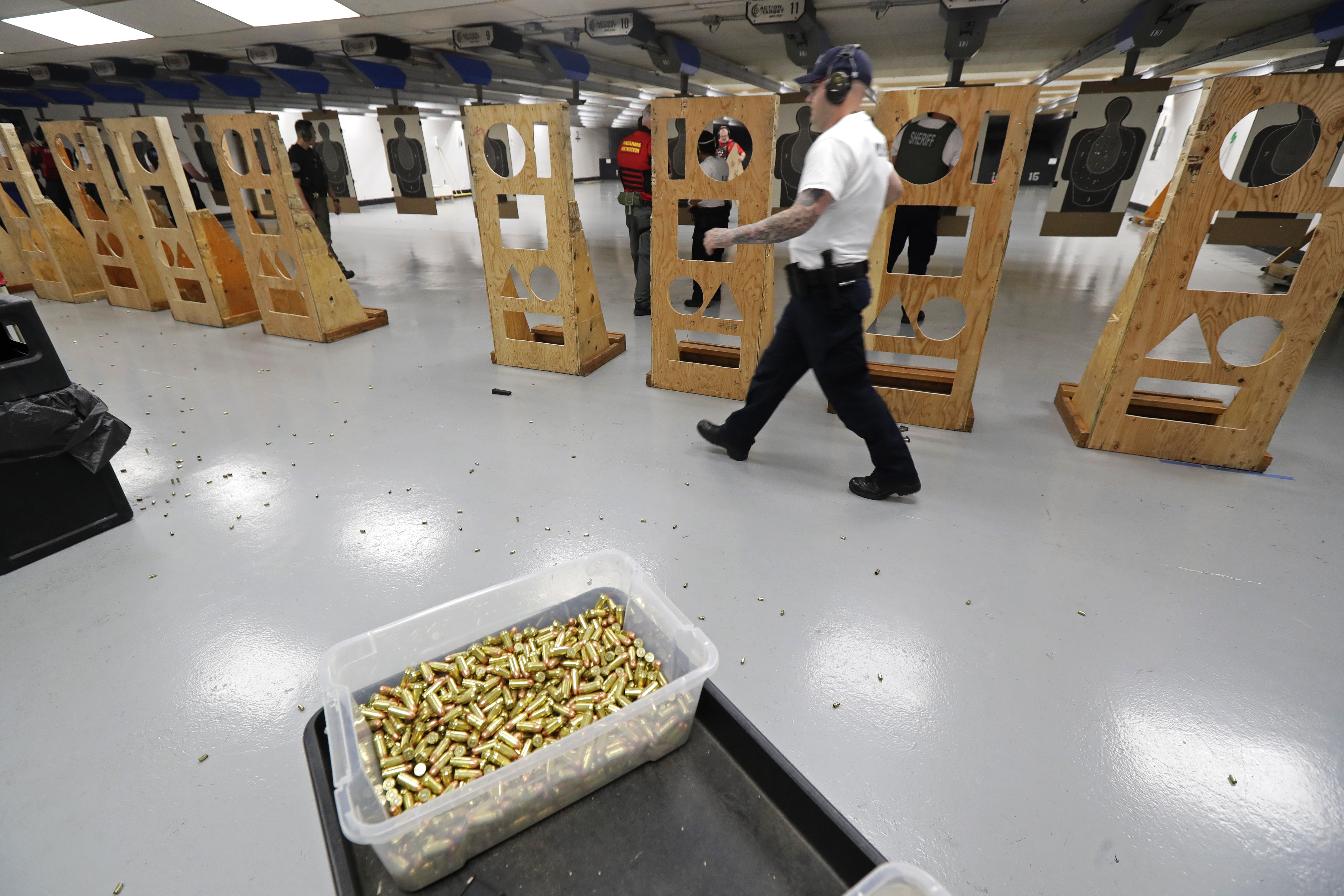 In this July 16, 2019 photo, an officer taking part in training walks near a box of ammunition at the Washington State Criminal Justice Training Commission in Burien, Wash.