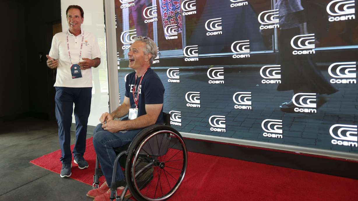 Fraser Bullock, president and CEO of the Salt Lake City-Utah Committee for the Games, and Chris Waddell, Paralympic sit-skier and wheelchair track athlete, attend a live immersive watch party for the Olympics at Cosm Experience Center in Salt Lake City on Friday.