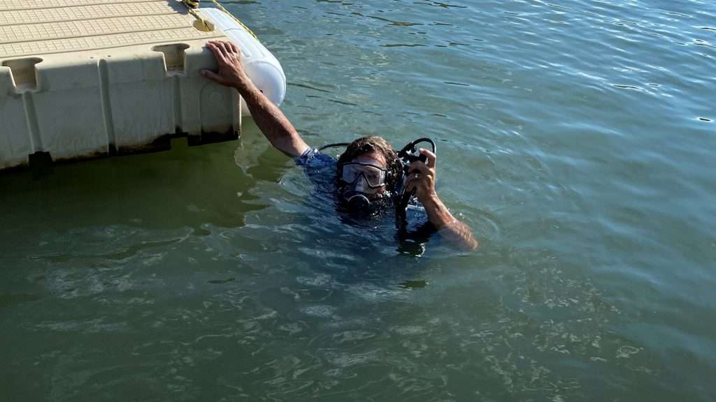 Paul Avner goes scuba-diving Thursday in order to move anchors due to lowering water levels at Utah reservoirs.