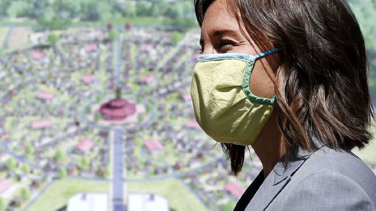 Salt Lake City Mayor Erin Mendenhall stands in front of a drawing for the Other Side Village — a tiny home community to serve people experiencing chronic homelessness — at the Salt Lake City-County Building on Thursday. City leaders are looking for ways to cut costs and streamline planning processes for building affordable housing — from tiny homes to mother-in-law
basement apartments — and they’re hoping cash prizes will attract talent to help.
