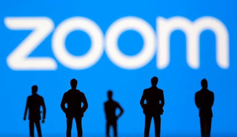 Small toy figures are seen in front of Zoom logo in this illustration picture taken March 15, 2021.