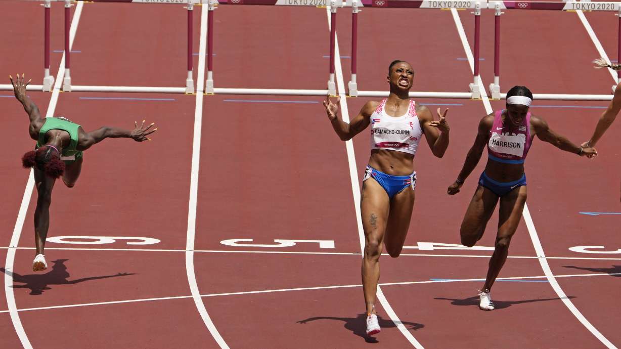 Jasmine Camacho-Quinn, of Puerto Rico, center, celebrates after winning the gold in the women's 100-meters hurdles final ahead of Kendra Harrison, of United States, silver, right, and Tobi Amusan, of Nigeria, fourth, at the 2020 Summer Olympics, Monday, Aug. 2, 2021, in Tokyo, Japan.