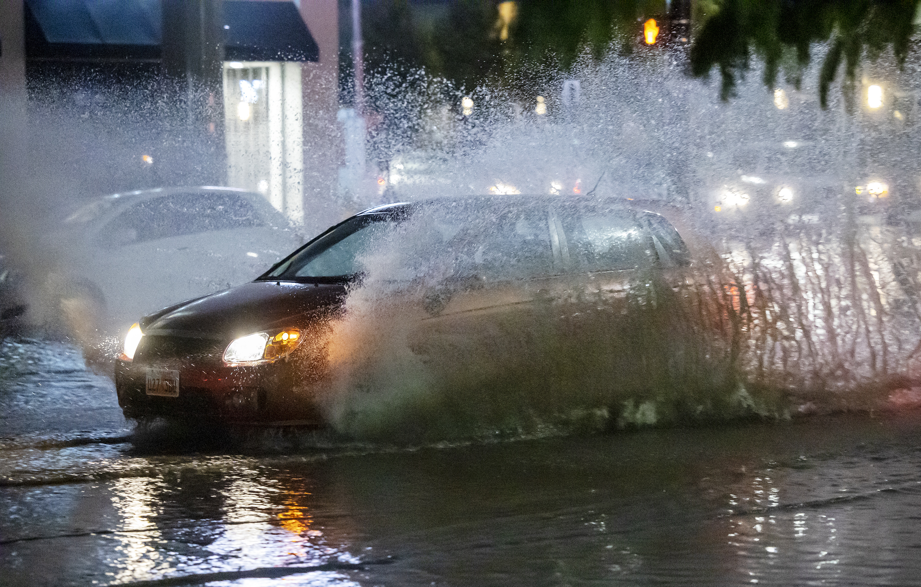 Cars splash through water at 600 South and State Street in Salt Lake City after heavy rains hit northern Utah on Sunday, Aug. 1, 2021.