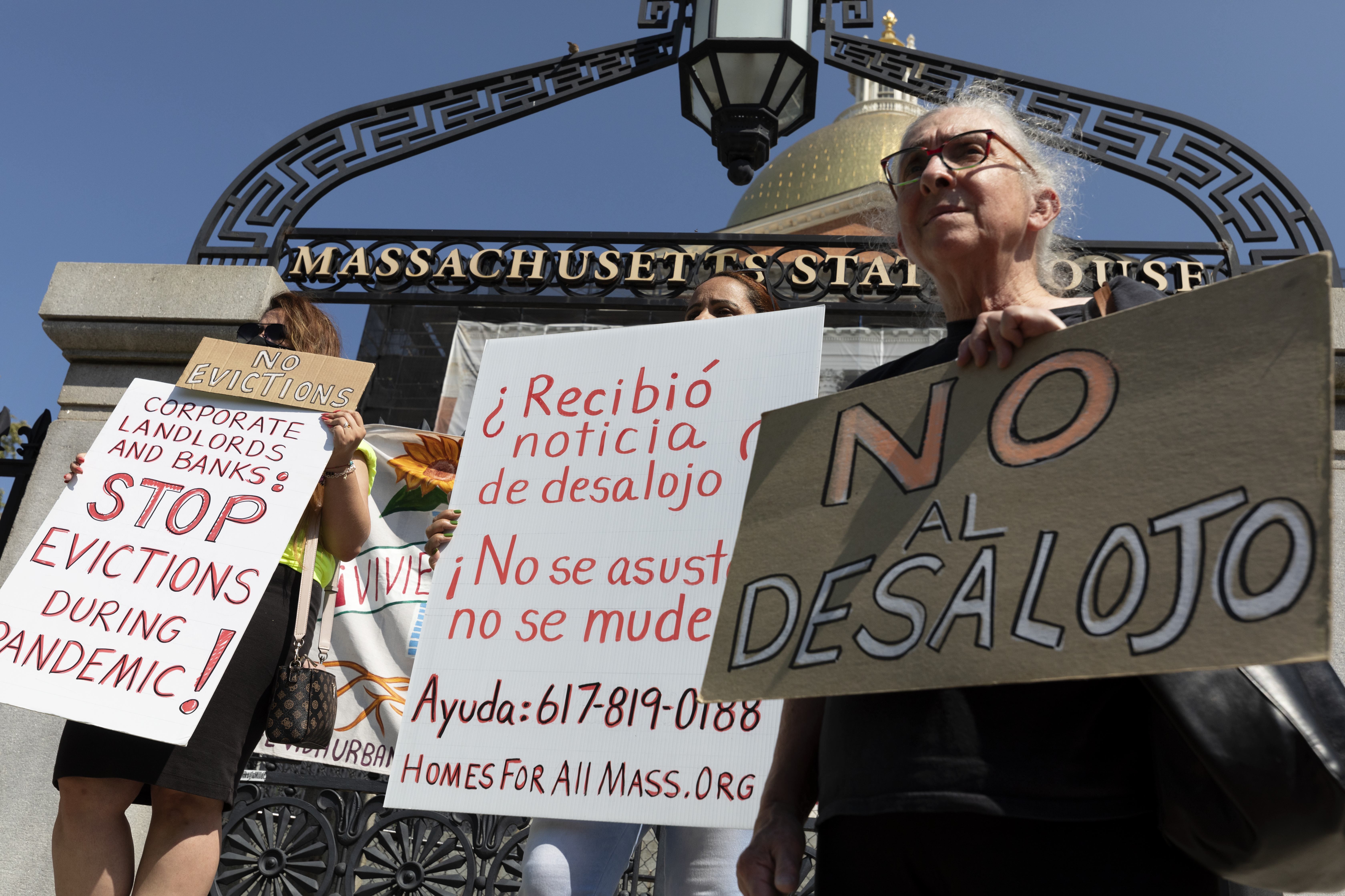 People from a coalition of housing justice groups hold signs protesting evictions during a news conference outside the Statehouse, Friday, July 30, 2021, in Boston. Evictions, which have mostly been on pause during the pandemic, were expected to ramp up Monday after the Biden administration allowed the federal moratorium to expire over the weekend and Congress was unable to do anything to extend it.