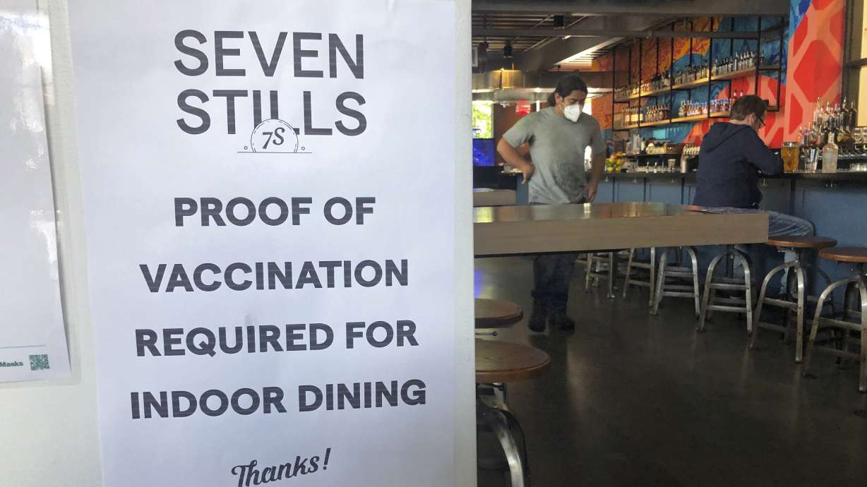 A proof of vaccination sign is posted at a bar in San Francisco on Thursday, July 29, 2021. Until now, many employers had taken a passive approach to their unvaccinated workers, relying outreach and incentives. But that has been shifting, with vaccine mandates gaining momentum.