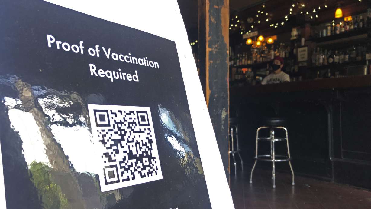 A proof of vaccination sign is posted at a bar in San Francisco on July 29. Until now, many employers had taken a passive approach to their unvaccinated workers, relying on outreach and incentives. But that has been shifting, with vaccine mandates gaining momentum.