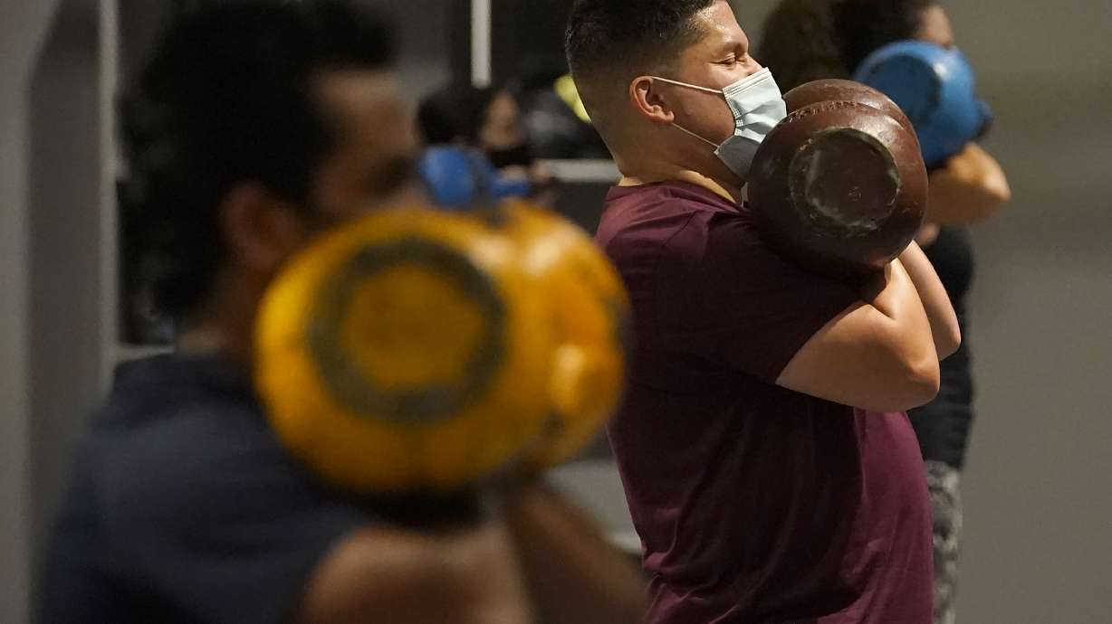 Juan Avellan, center, and others wear masks while working out in an indoor class at a Hit Fit SF gym in San Francisco in November of 2020. Health officials in San Francisco and six other Bay Area counties announced they are reinstating a mask mandate for all indoor settings as COVID-19 infections surge because of the highly contagious delta variant.