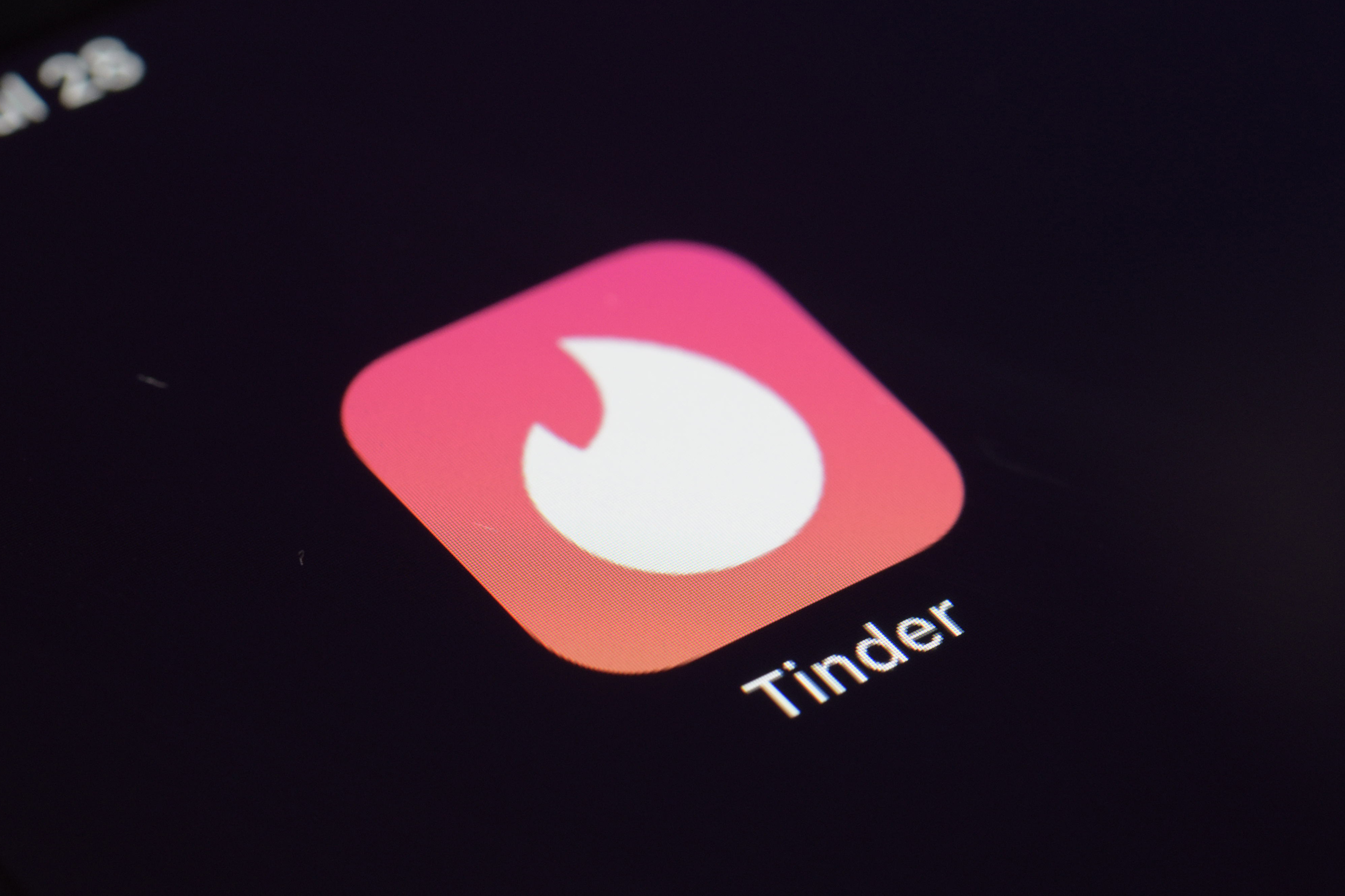 This Tuesday, July 28, 2020, photo shows the icon for the Tinder dating app on a device in New York. The use of dating apps in the last 18 months of the pandemic has surged around the globe. Tinder reported 2020 as its busiest year.