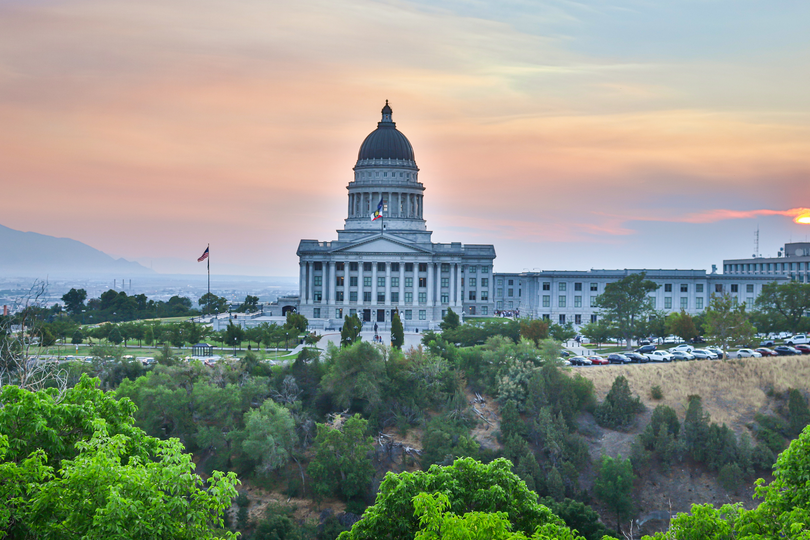 Smoke from Western wildfires settles over the Salt Lake Valley as the sun sets on Tuesday. The smoke is expected to remain in Utah over at least the next few days.